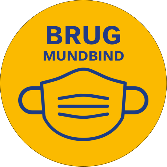En rund gul etiket med en maskeillustration og med teksten "Brug mundbind"