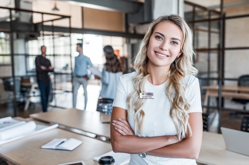 Kvinde i et kontormiljø der har et bagdepoint professionelt navneskilt på.