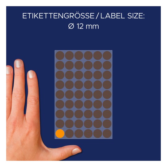 Billedet viser en hånd ved siden af et ark med etiketter, der angiver en etiketterstørrelse på 12 mm i diameter med mørkebrune cirkler og én orange cirkel.
