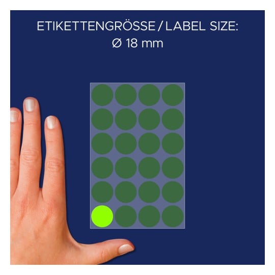 Billedet viser en hånd ved siden af et ark med cirkulære etiketter, for det meste grønne med én lys grøn etiket nederst til venstre. Etikettens størrelse er angivet som Ø 18 mm.
