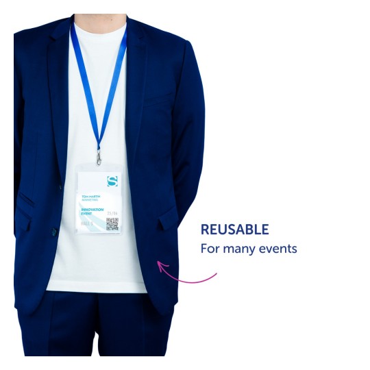 Billedet viser en person iført en blå dragt med en hvid t-shirt under. Et navneskilt hænger rundt om deres hals og viser navnet 'Tom Martin' sammen med oplysninger om arrangementet. Skiltet understreger, at det kan bruges igen til flere arrangementer.
