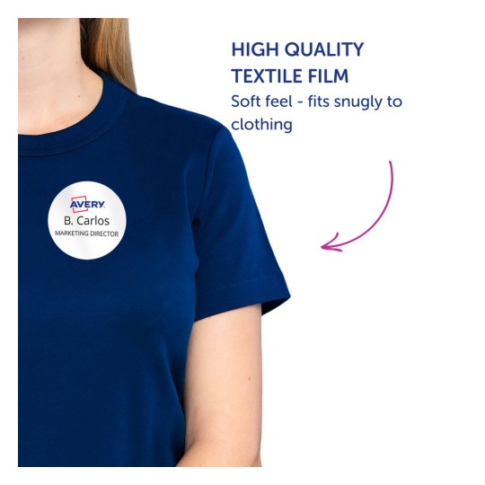 Billedet viser en person iført en mørkeblå skjorte med en rund navneskilt, der viser 'B. Carlos, MARKETINGDIREKTØR'. Der er tekst, der promoverer 'High Quality Textile Film' med en beskrivelse af, at den har en blød fornemmelse og sidder tæt på tøjet.