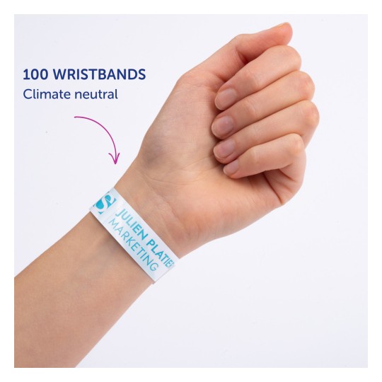 Billedet viser en persons hånd iført et armbånd, hvor der står '100 ARMBÅND Klimaneutral' med 'JULIEN PLATTER MARKETING' trykt på det.
