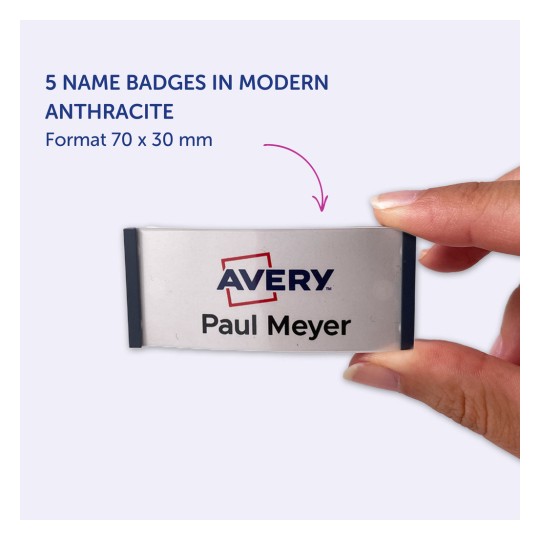 Billedet viser en person, der holder et navneskilt med teksten 'Avery Paul Meyer', og fremhæver fem navneskilte i moderne antracitfarve, med dimensioner på 70 x 30 mm.