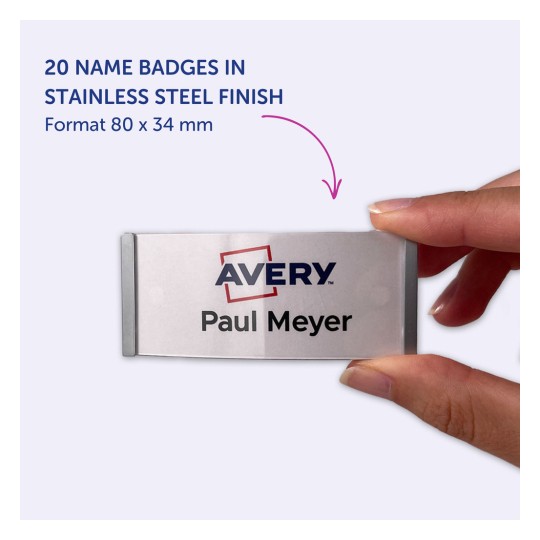 Billedet viser en hånd, der holder et navneskilt med navnet 'Paul Meyer' og logoet 'Avery'. Skiltet har en finish i rustfrit stål, måler 80 x 34 mm, og der er 20 skilte opført i dette format.