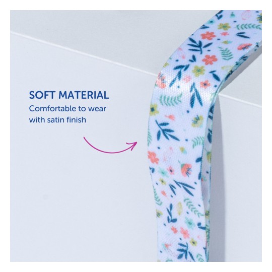 Billedet viser et blødt bånd med et blomstermønster, ledsaget af tekst, der angiver dens behagelige satinfinish.