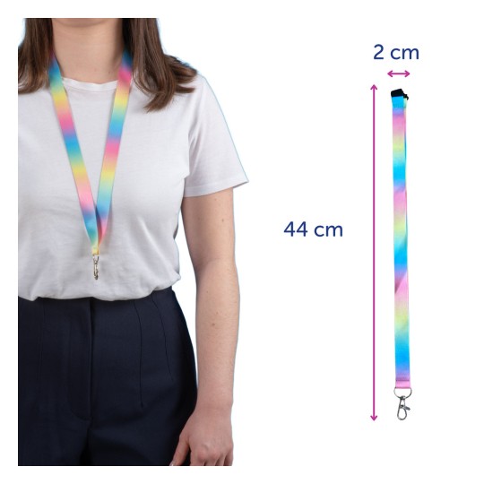 Billedet viser en person med en farverig nøglerem med en klips. Nøgleremmen har et gradientdesign med pastelfarver, måler 44 cm i længden og 2 cm i bredden.