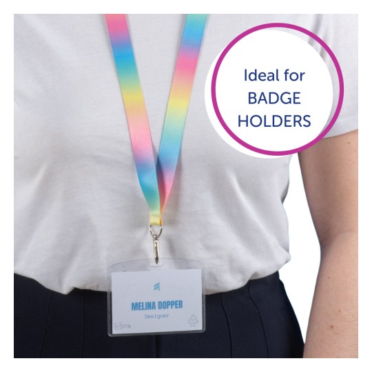 Billedet viser en person med en farverig nøglesnor og en badge, der siger 'Melina Dopper, Designer'. Nøglesnoren skifter fra pink til gul til blå, og der er en taleboble, der siger 'Ideel til BADGEHOLDERE.'