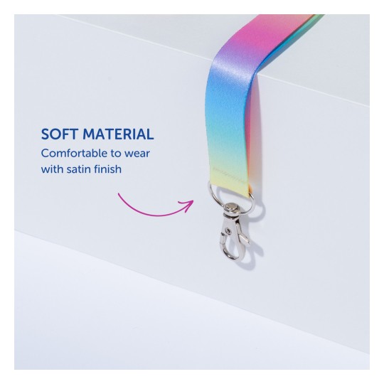 Billedet viser en farverig lanyard med satinfinish og en sølvklips. Det fremhæver det bløde materiale og komforten ved lanyardens design, ledsaget af beskrivende tekst der understreger disse egenskaber.