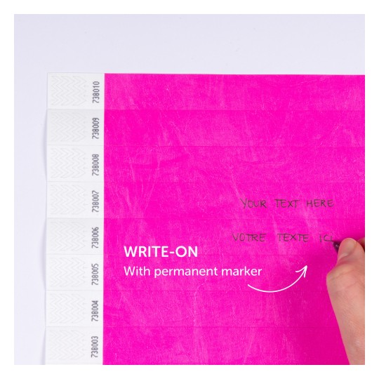 Billedet viser en lys pink overflade med instruktioner til at skrive på den med en permanent marker. Der er linjer til tekst og en hånd, der holder en marker, hvilket antyder tilpasning eller mærkning.
