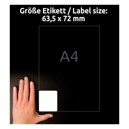 Billedet viser en hånd ved siden af en størrelsesreference for en etiket, med dimensioner på 63,5 x 72 mm, og bogstavet 'A4' angivet. Baggrunden er mørk, hvilket fremhæver etikettens størrelse.