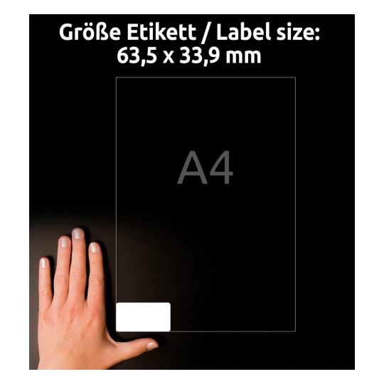 Billedet skildrer en hånd, der holder et transparent ark mærket 'A4'. Det inkluderer tekst, der angiver etiketstørrelsen: 63,5 x 33,9 mm, sat mod en mørk baggrund.