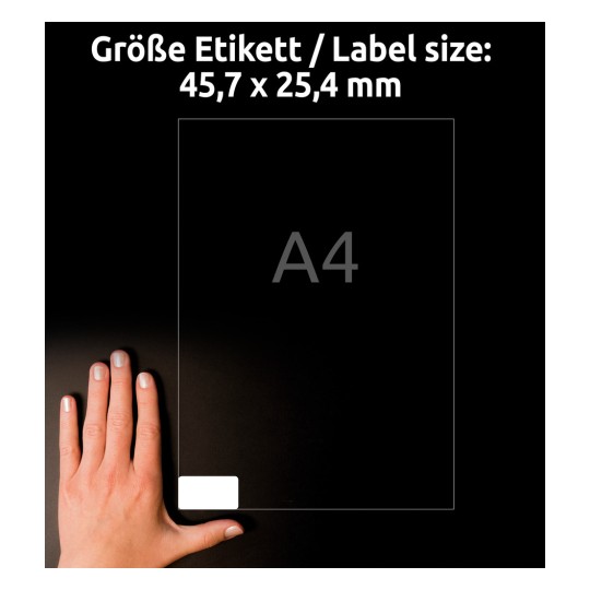 Billedet viser en hånd, der holder en etiket med dimensionerne 45,7 x 25,4 mm. Etiketten er størrelse til at passe på et A4-papir, vist på en mørk baggrund.