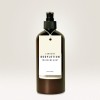 Billedet viser en mørkebrun flaske med bodylotion med en etiket, der læser 'LEAVE IN BODYLOTION TROCKENE HAUT' og 'Intensive Pflege'. Flasken har en pumpe-top og et minimalistisk design.