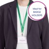Billedet viser en person iført en blazer og en grøn snor med en kortholder, der viser et navn og en titel.