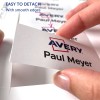 Billedet viser en hånd, der holder et kort mærket 'Avery' og 'Paul Meyer', hvilket indikerer, at det er nemt at fjerne med glatte kanter. Flere kort er synlige i baggrunden.