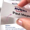 Billedet viser en hånd, der holder et printet indlæg med teksten 'Paul Meyer' og AVERY-logoet, og fremhæver detaljer om, at indlæggene er lavet af papir af høj kvalitet med glatte kanter.