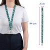 Et billede af en kvinde med en mønstret nøglesnor omkring halsen. Nøglesnoren har et blomstermønster og er 44 cm lang med en bredde på 2 cm.