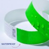 Billedet viser to armbånd; det ene er lysegrønt med vanddråber på, mens det andet er hvidt med et tekstureret design. Ordet 'WATERPROOF' er vist ved siden af armbåndene, hvilket antyder den grønne armbånds vandtætte egenskab.